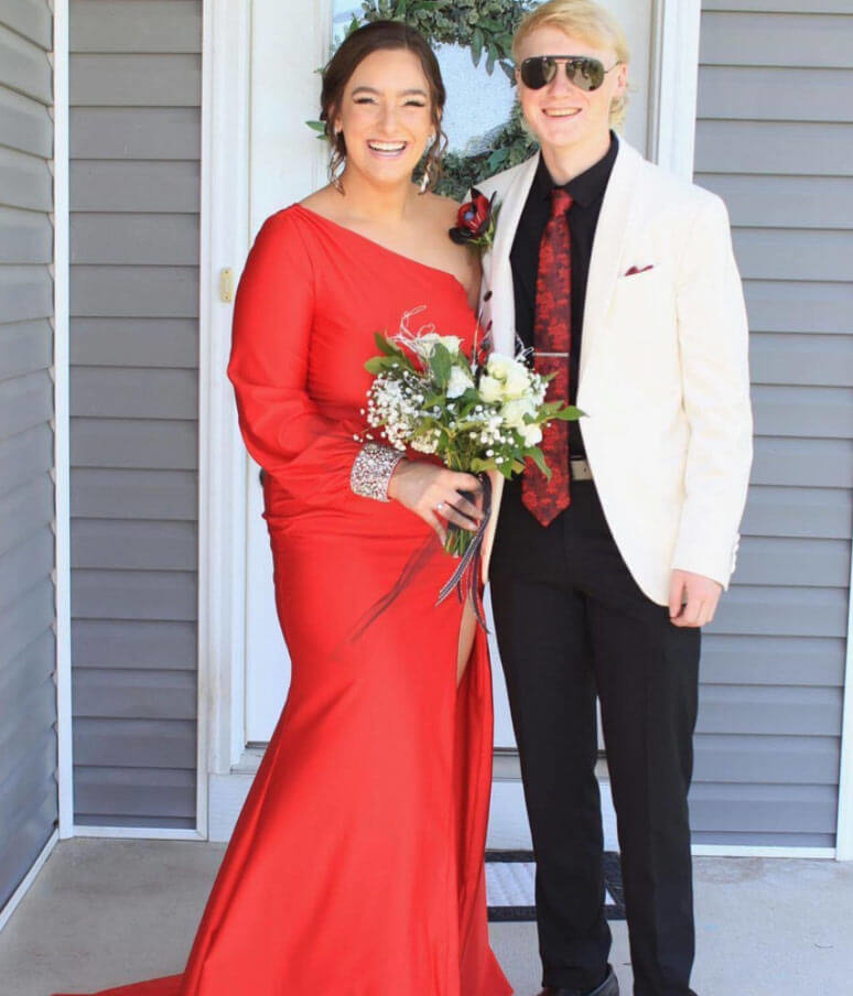 Сouple wearing a red gown and a white suit